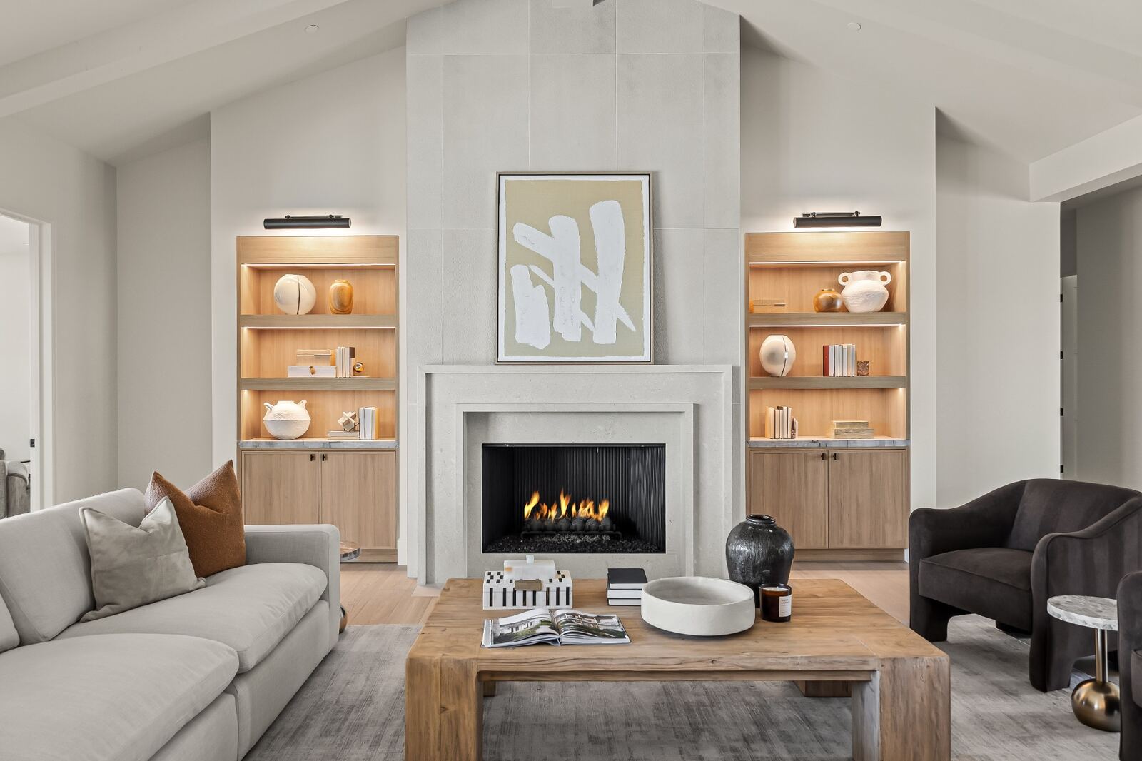 A living room fireplace with lit built-in shelving in an Ella Lee custom home