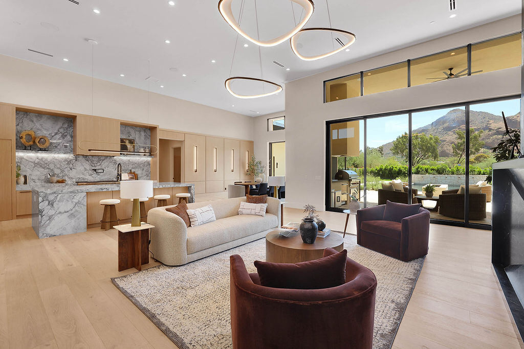 An open great room with a kitchen island and mountain views