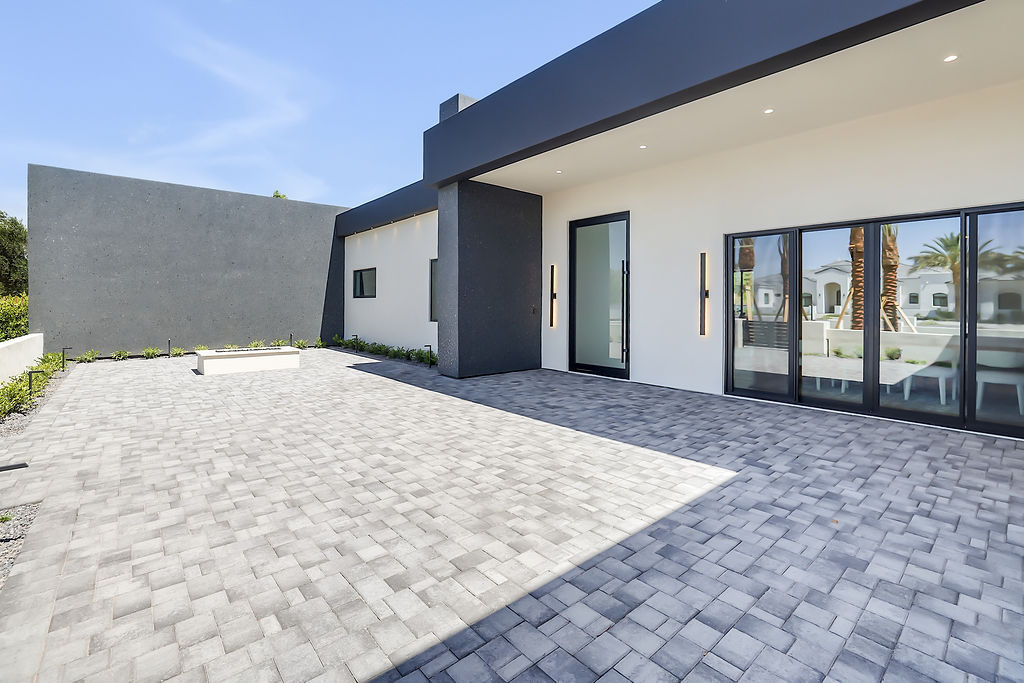 The exterior of a custom home with a paver courtyard