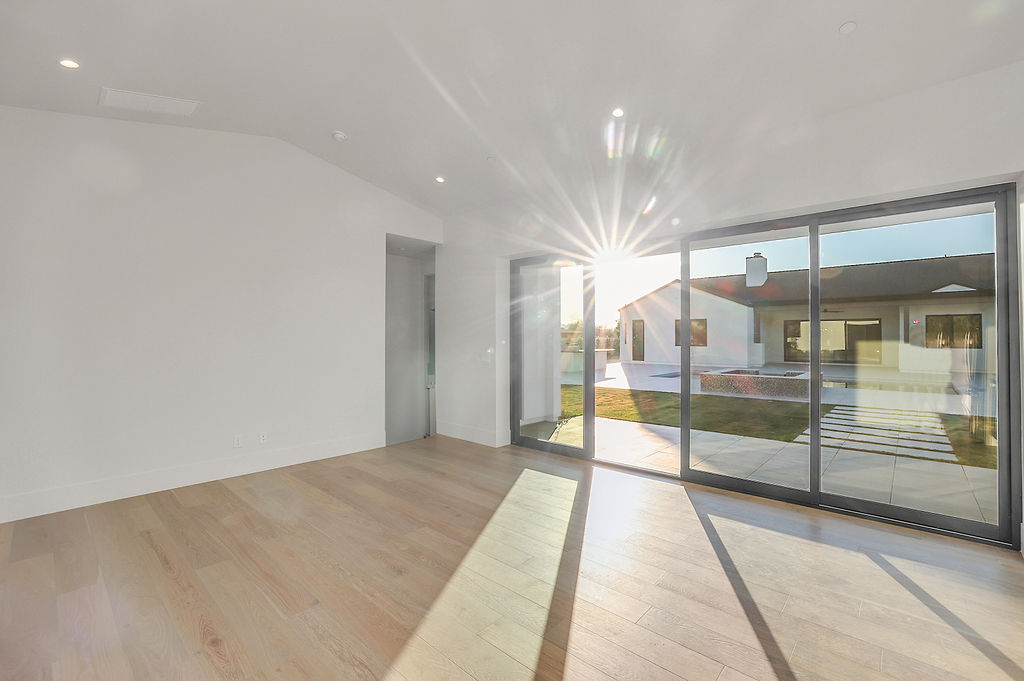 A sunlit living room opening to the backyard