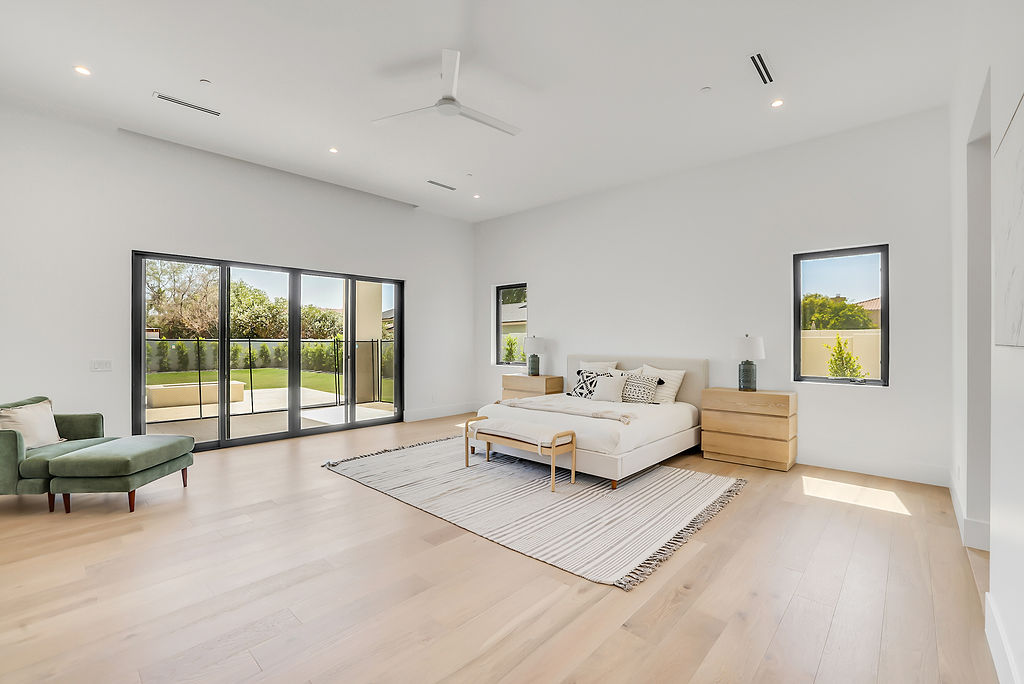 A finished primary bedroom opening to the backyard
