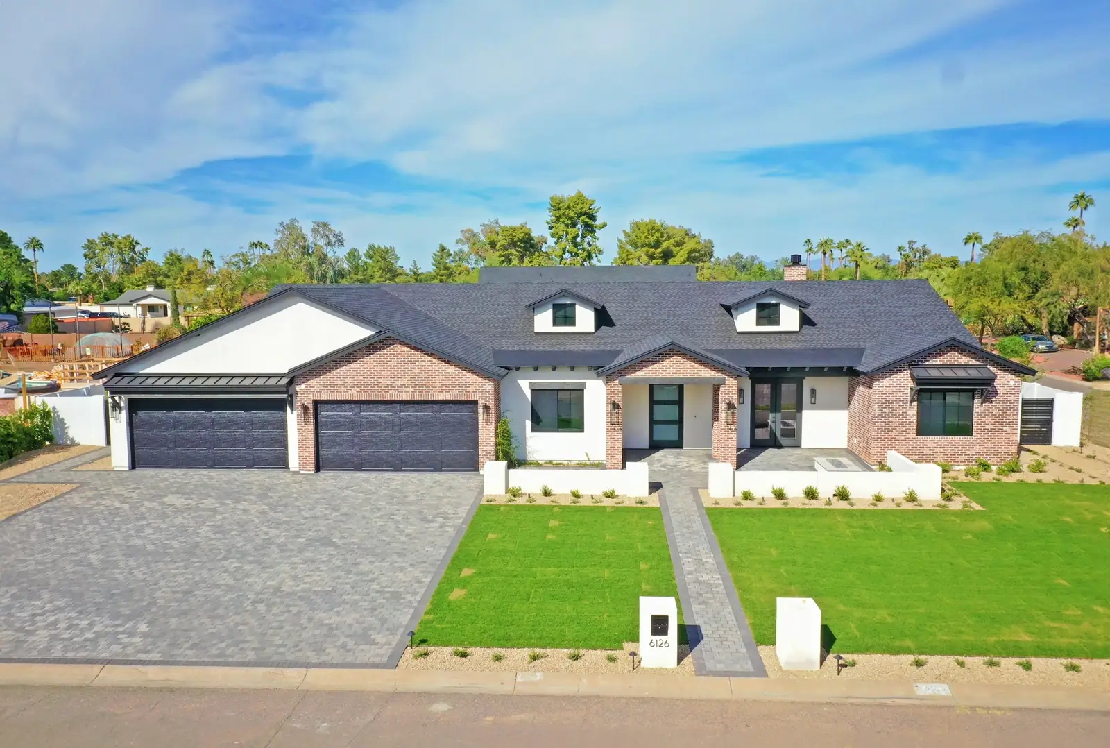 Aerial view of a modern custom home with pool and sport court
